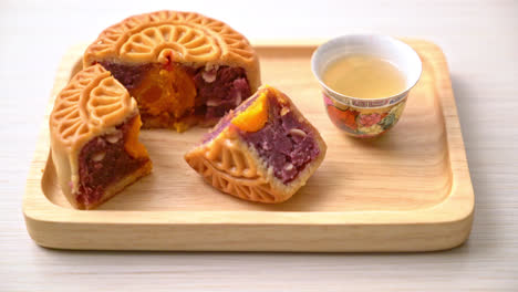 Pastel-De-Luna-Chino-Sabor-A-Batata-Morada-Y-Yema-De-Huevo-Con-Té-En-Placa-De-Madera