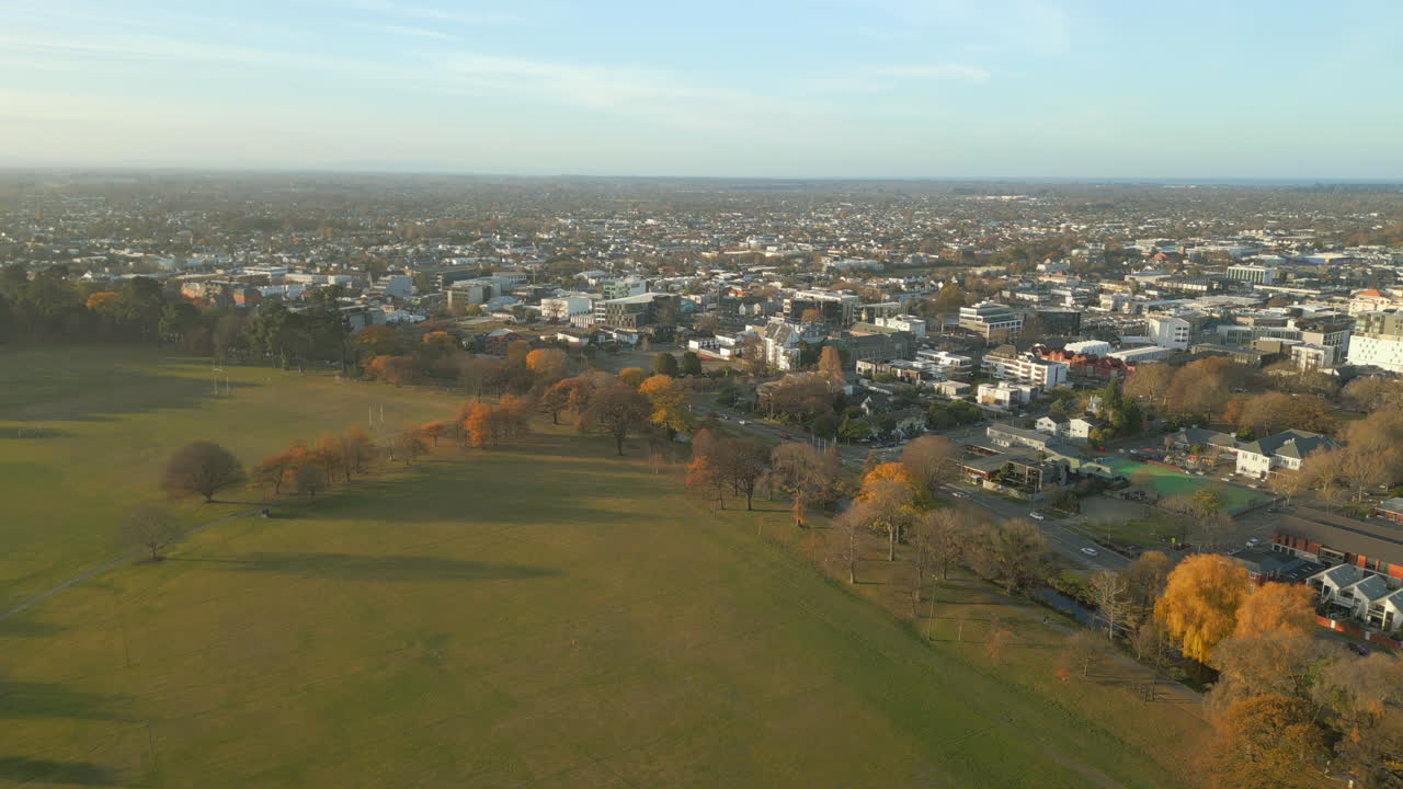 North Hagley Park, Christchurch, Uusi-Seelanti: Kirkas taivas, pohjoiseen suuntautuva dronekuvaus vasemmalle. 4K 60 FPS.