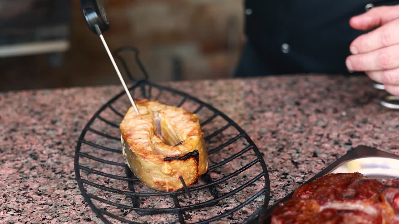 이 그릴 된 연어 의 익은 상태 를 확인 하고 있다