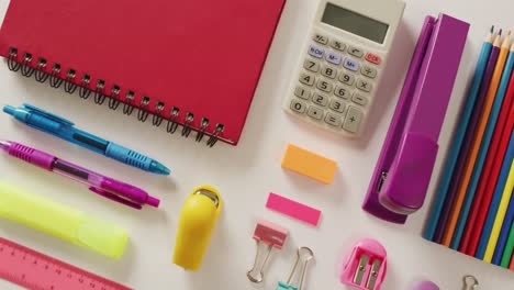 video of composition of school items with notebook and calculator on white background