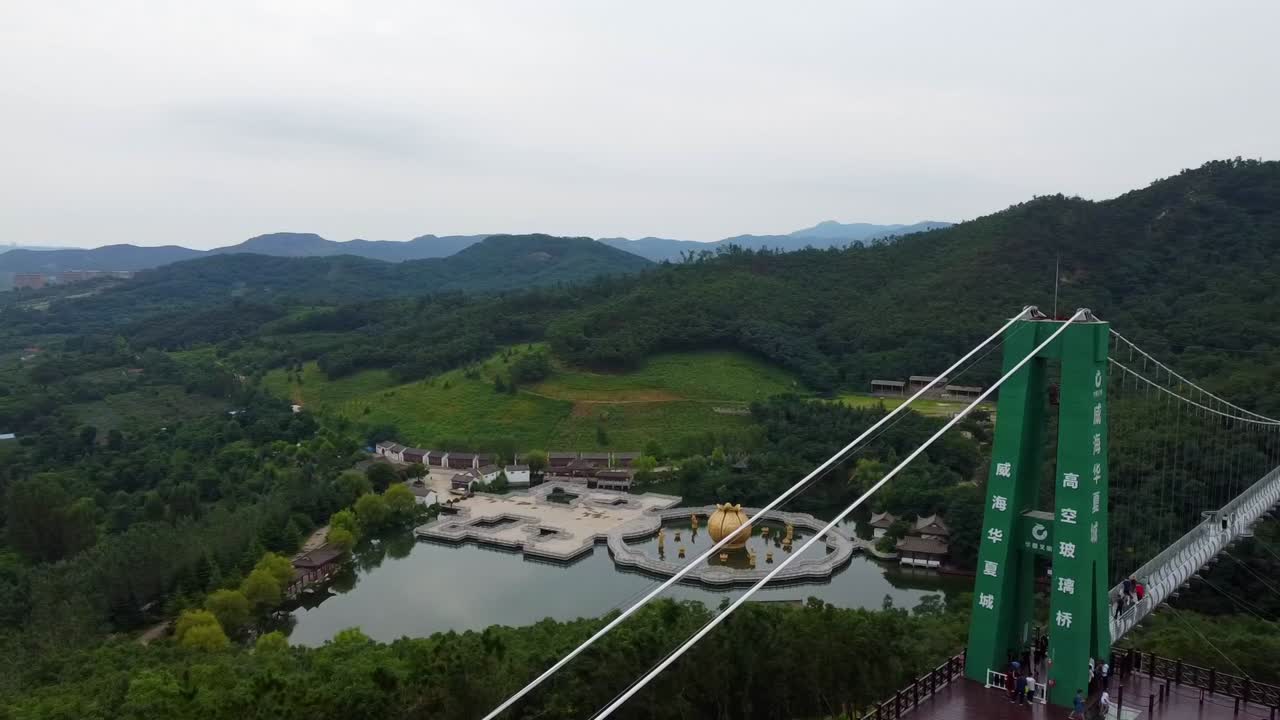 aerial del parque temático huaxiacheng en la ciudad de weihai china dron pano de puente colgante, atracción para la familia china durante las vacaciones