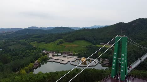 Antena-Del-Parque-Temático-Huaxiacheng-En-La-Ciudad-De-Weihai-China-Drone-Pano-Del-Puente-Colgante,-Atracción-Para-La-Familia-China-Durante-Las-Vacaciones