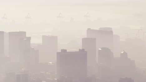 general view of cityscape with multiple tall skyscrapers and buildings covered in fog