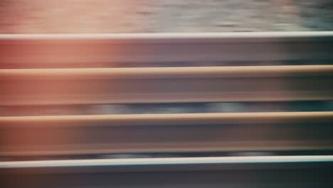 abstract pov through train window capturing rail tracks passing by in high speed, showcasing movement and urban landscapes