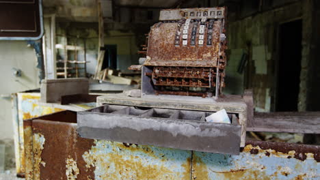 Rustic-antique-cash-register-in-abandoned-store-in-Pripyat,-zoom-out-view