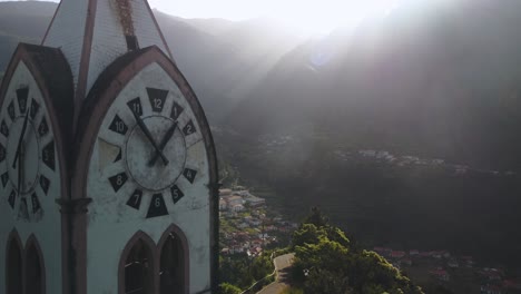 Drone-shot-of-church-clocktower-of-Fatima-chapel-on-hill-in-Sao-Vicente-town,-Madeira,-Portugal