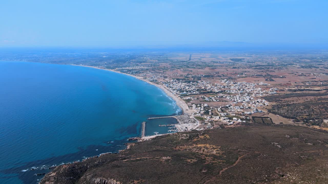 : A breathtaking aerial view captures the serene intersection of Tunisia's rugged coastline and expansive desert, showcasing the tranquil beauty of nature and human settlement in harmony.