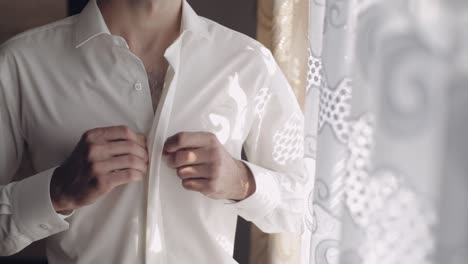 Handsome-groom-fixes-his-shirt.-Wedding-morning.-Slow-motion