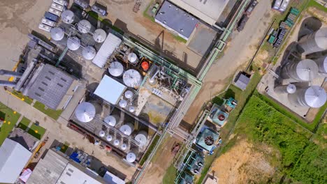 Aerial-top-down-shot-over-industrial-Barcelo-Rum-Factory-with-sugar-cane-fields-during-sunlight-in-Dominican-Republic