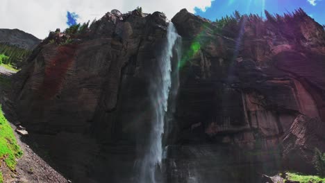 summer green telluride bridal veil falls waterfall colorado powerplant house aerial drone box canyon black bear pass road rocky mountains 4wd hiking blue sky cliffs uncompahgre forest pan down motion