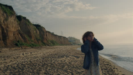 dreamy girl walking on ocean beach. stylish woman watching sea landscape