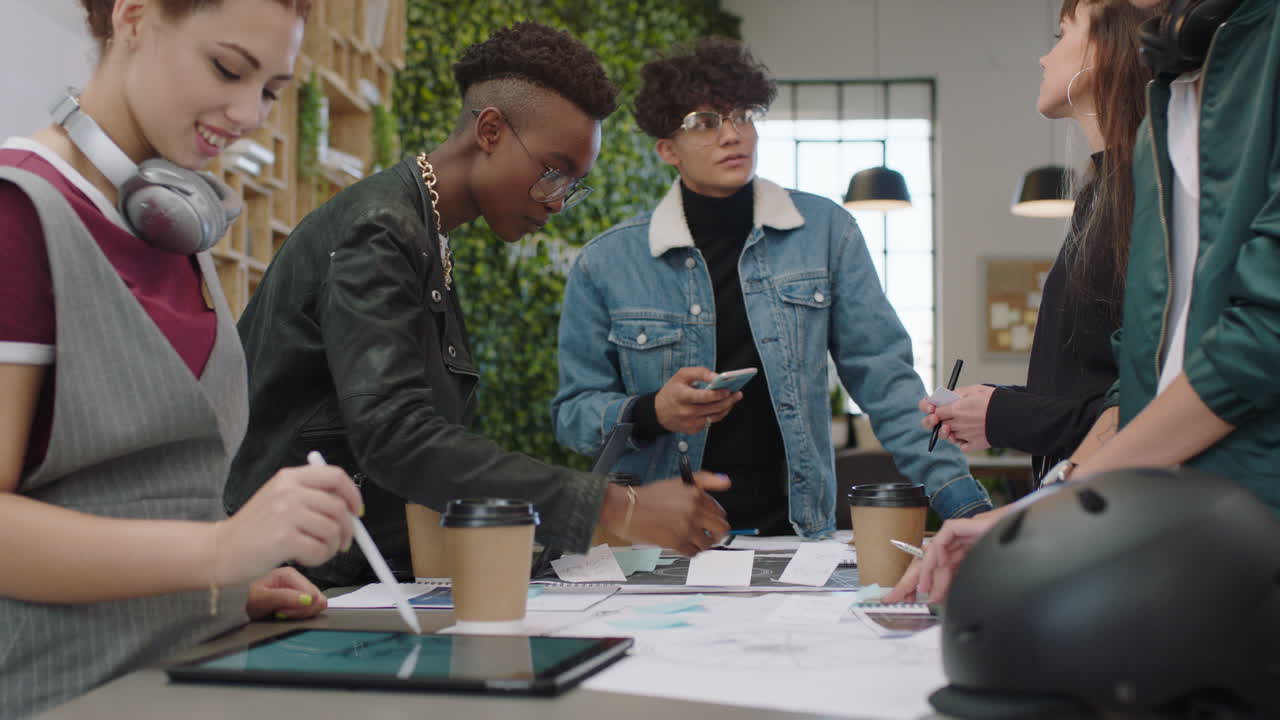 young engineers developing bicycle prototype using blueprint schematics multi ethnic studetns brainstorming future development collaborating sharing creative ideas in trendy office