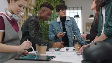 Jóvenes-Ingenieros-Desarrollando-Prototipos-De-Bicicletas-Utilizando-Esquemas-De-Planos.-Estudiantes-Multiétnicos-Intercambiando-Ideas-Sobre-El-Desarrollo-Futuro-Colaborando-Compartiendo-Ideas-Creativas-En-Una-Oficina-De-Moda.