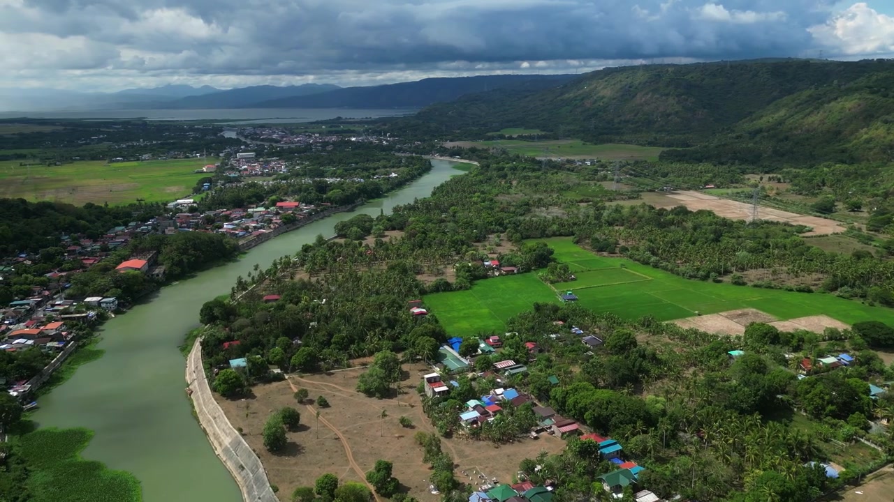 Drone luftpanorama over Pagsanjan, Laguna-provinsen, der viser flodnetværket, samfund langs floden, tropisk vegetation og det bjergrige landskab nær Sierra Madre-bjergkædens foden.