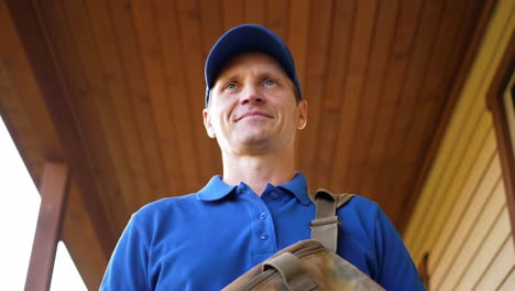 confident individual in blue attire posing with a satchel under a cozy wooden awning, exuding professionalism and approachability
