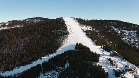 pista de esquí de descenso con esquiadores en el complejo montañoso de la república checa desde un dron