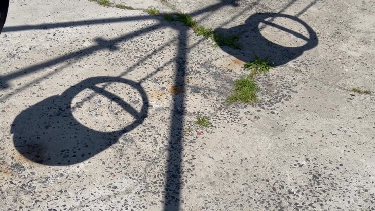 Empty Playground Swings Casting Long Shadows on Sunny Day