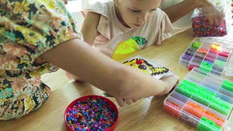 children creating pixel art with beads