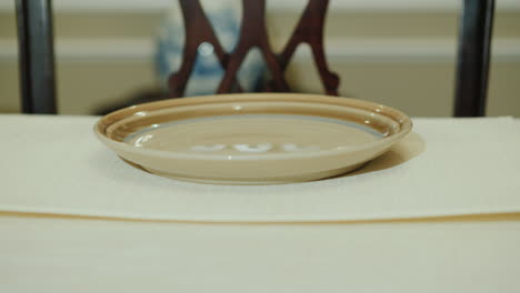 a woman serves a table in a jut home dining room