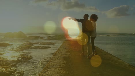 Animation-of-light-spots-over-african-american-couple-walking-and-holding-hands