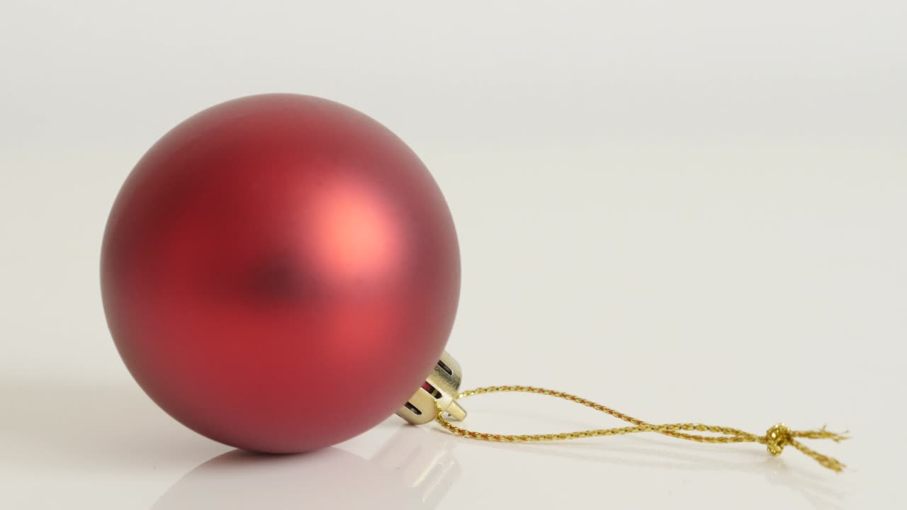 Bola de Natal vermelha com cordão dourado em inclinação lenta 4K