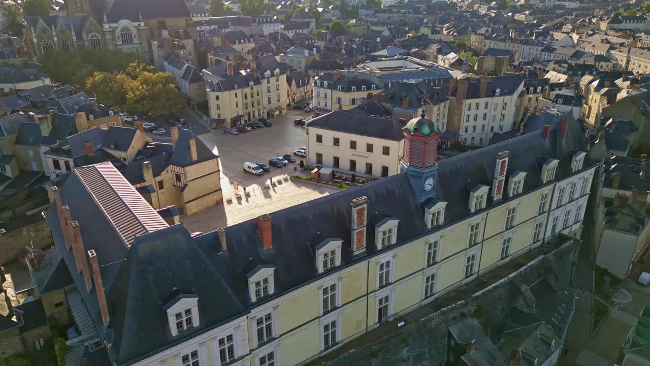 Château-Neuf castle, clock tower, courtyard, and old town architecture at golden hour, Laval, France. Aerial drone