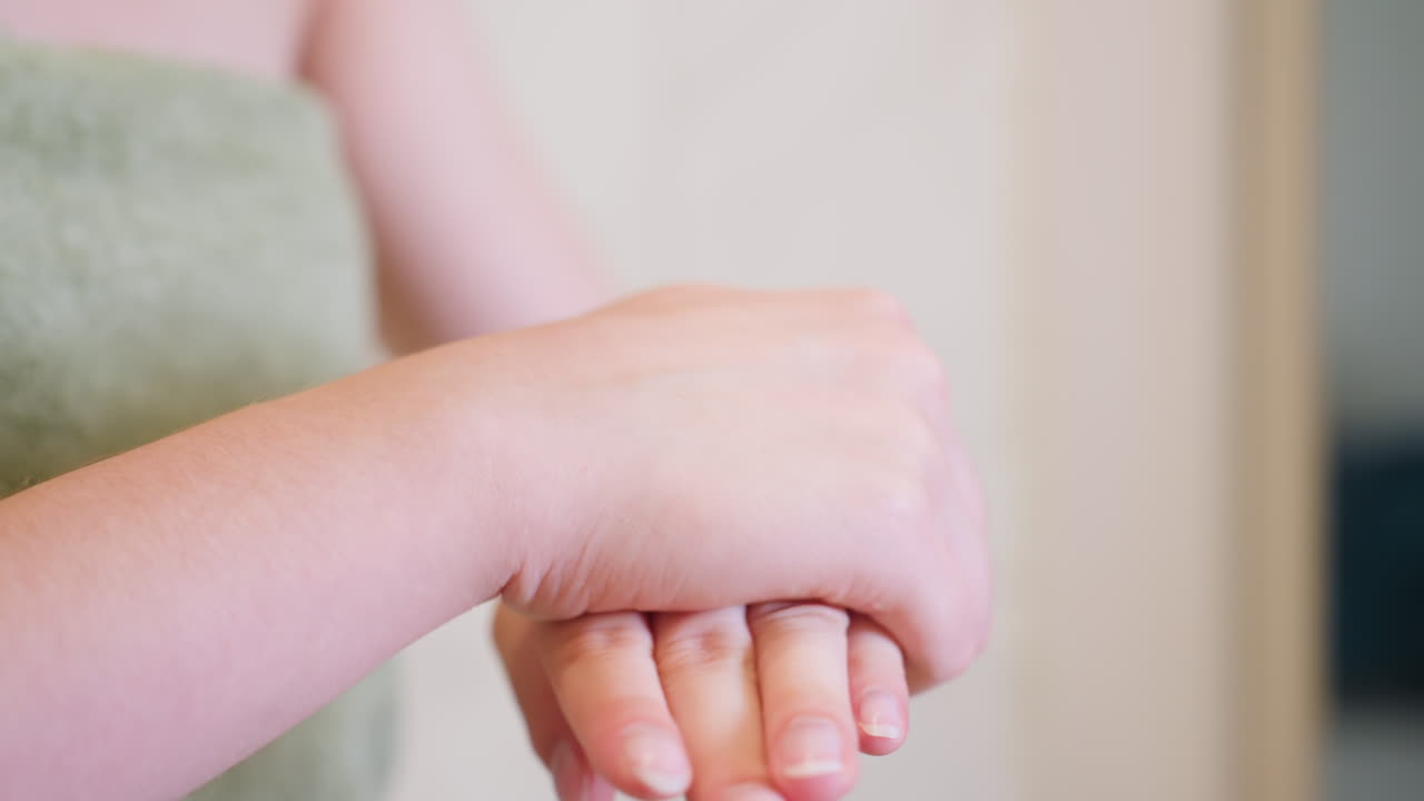 Close-up view of hands rubbing together, possibly applying cream or lotion after skincare routine, focus on smooth and moisturized skin, with a soft, gentle motion for personal care