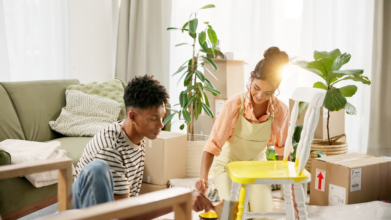 Couple painting chair while moving into new home