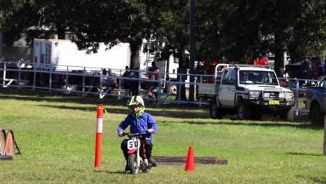 motorcyclist performing slalom around cones on grass