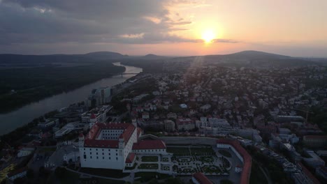 Aerial-flying-high-above-Bratislava-Castle-at-sunset,-Slovakia,-tilt-up