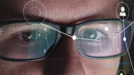 el hombre trabaja en una red global y clasifica las conexiones - la pantalla se refleja en sus gafas - primer plano