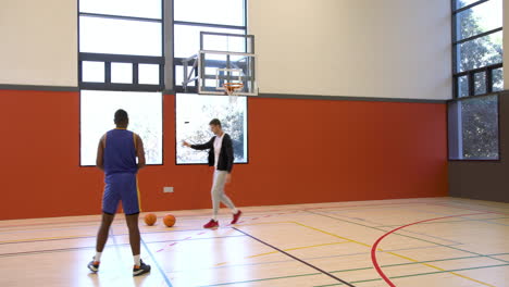 practicing basketball, coach and player focusing on dribbling skills in gym