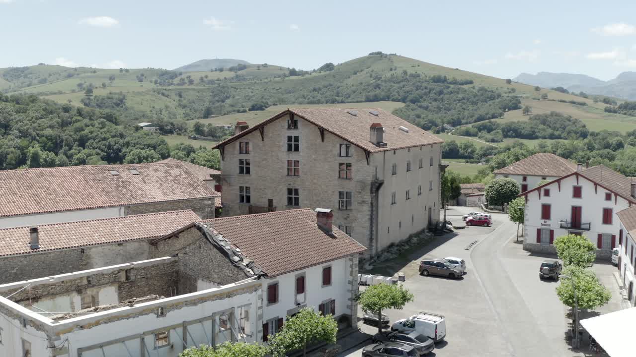 Aerial view of Ospitalea village square with traditional buildings and parked cars, Irissarry, France