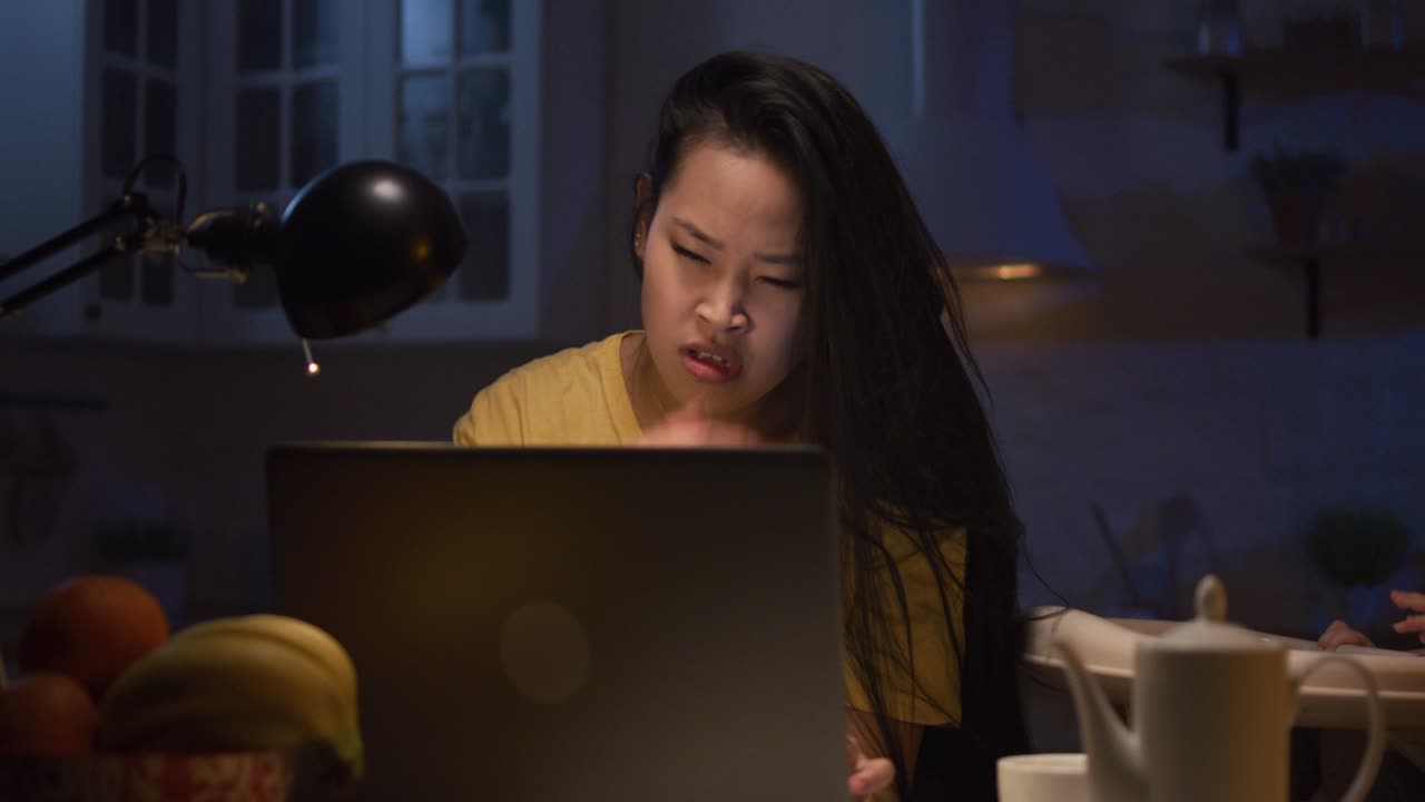 Woman Working Late Night on Laptop in Kitchen
