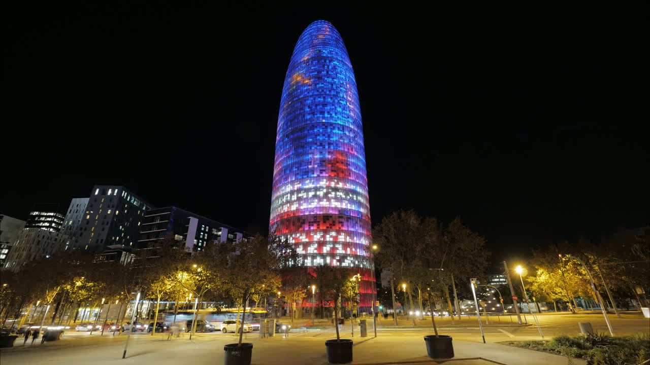 timelapse de barcelona con la torre iluminada agbar por la noche españa