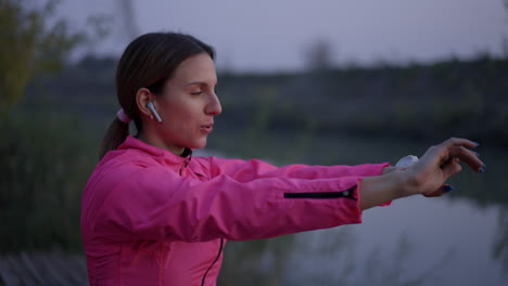 woman stretching and exercising outdoors by a river at dusk
