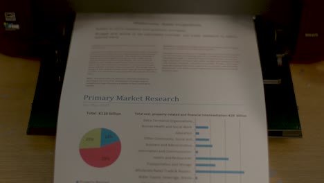 a male hand picking up a document from a printer tray, static close up