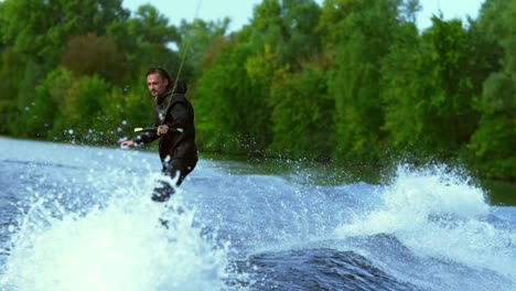 man riding board on waves. wake boarding rider training on wakeboard boat