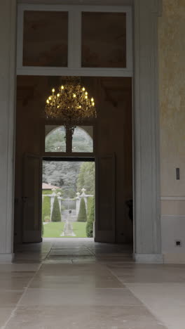 grand entrance with chandelier leading to manicured garden