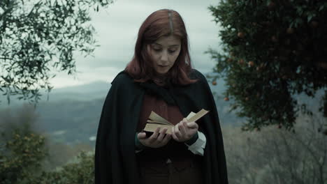 young woman reads a twist in the story of her novel book in mountains