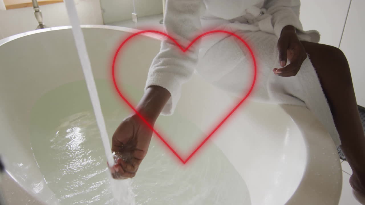 Person in white robe filling bathtub with water, red heart animation overlay