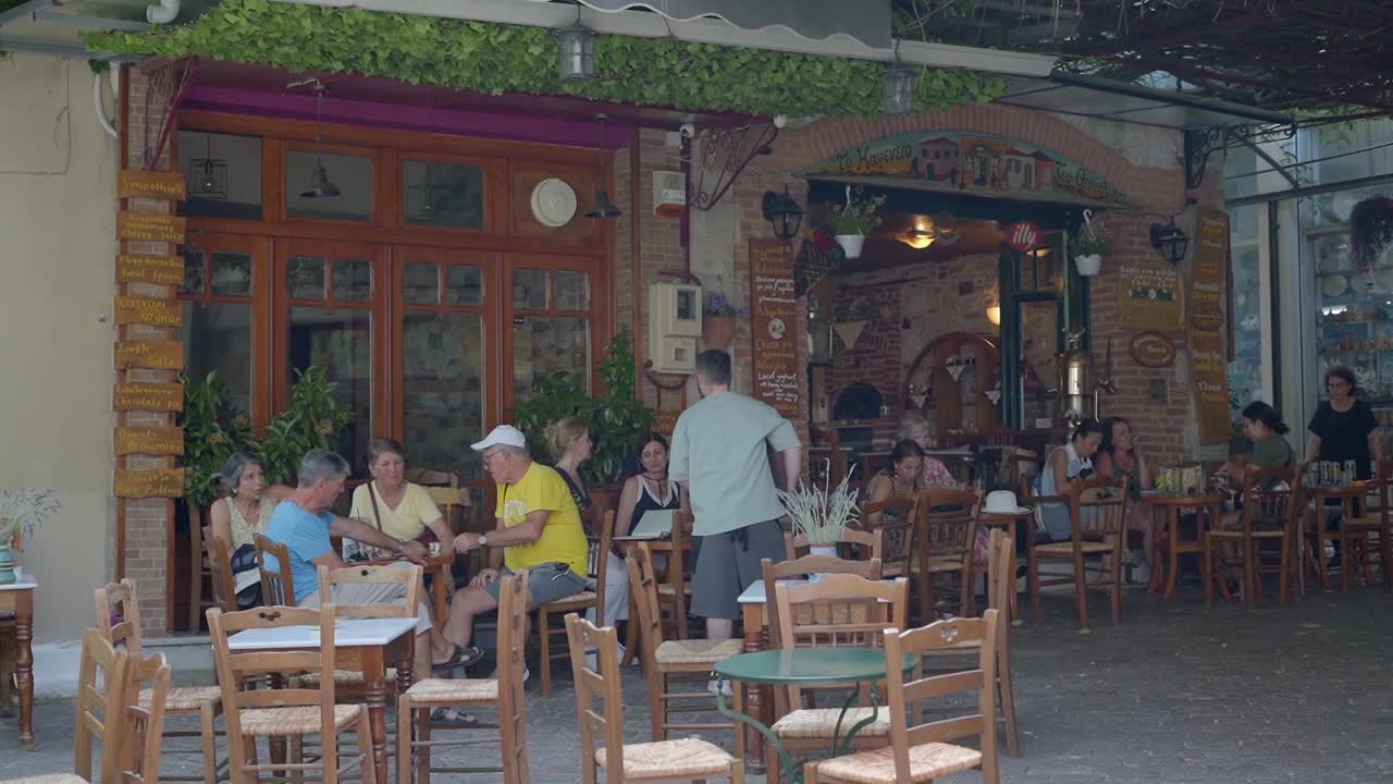 Tourist at traditional Greek taverna in old streets of Agiasos village, Gimbal shot