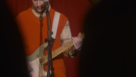 músico masculino tocando la guitarra y cantando durante la actuación de música en vivo 6