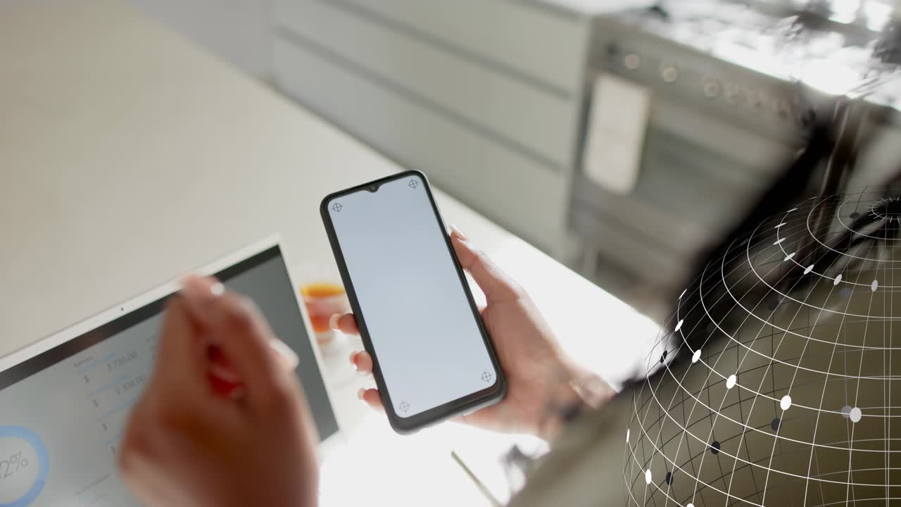 Woman holding phone tilting starting tech orb overlay on it while gesturing by tablet showing data