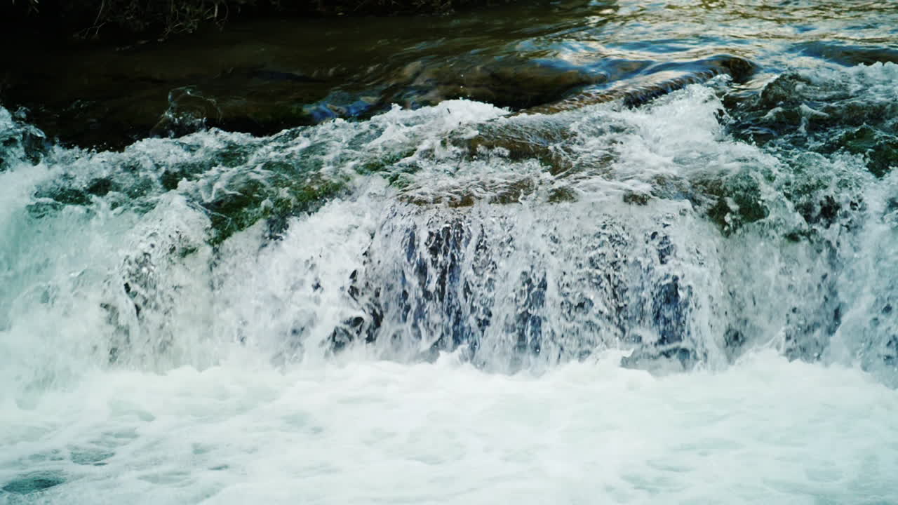 Eau cristalline de rivière de montagne s'écoulant sur les rochers