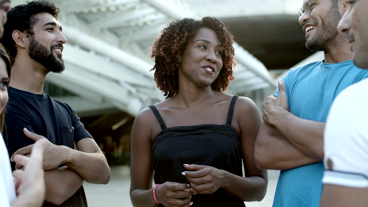 Laughing friends standing on street and talking