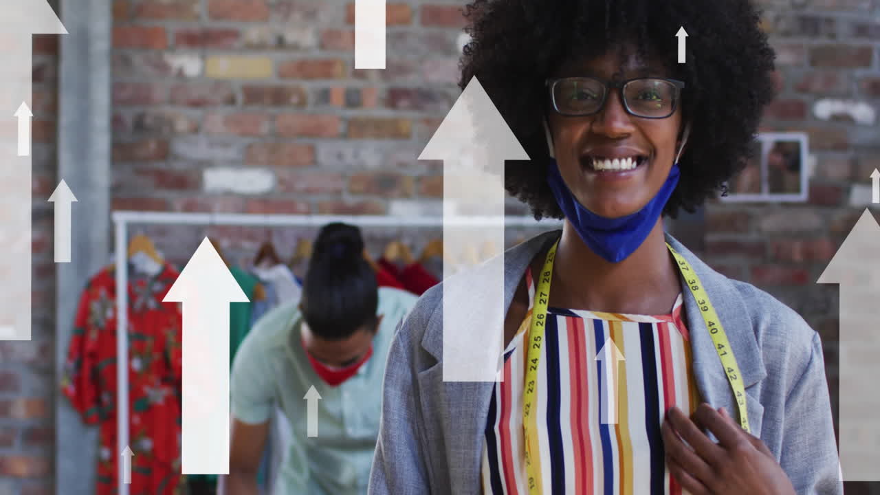 Animation of arrows over diverse fashion designers working in face masks