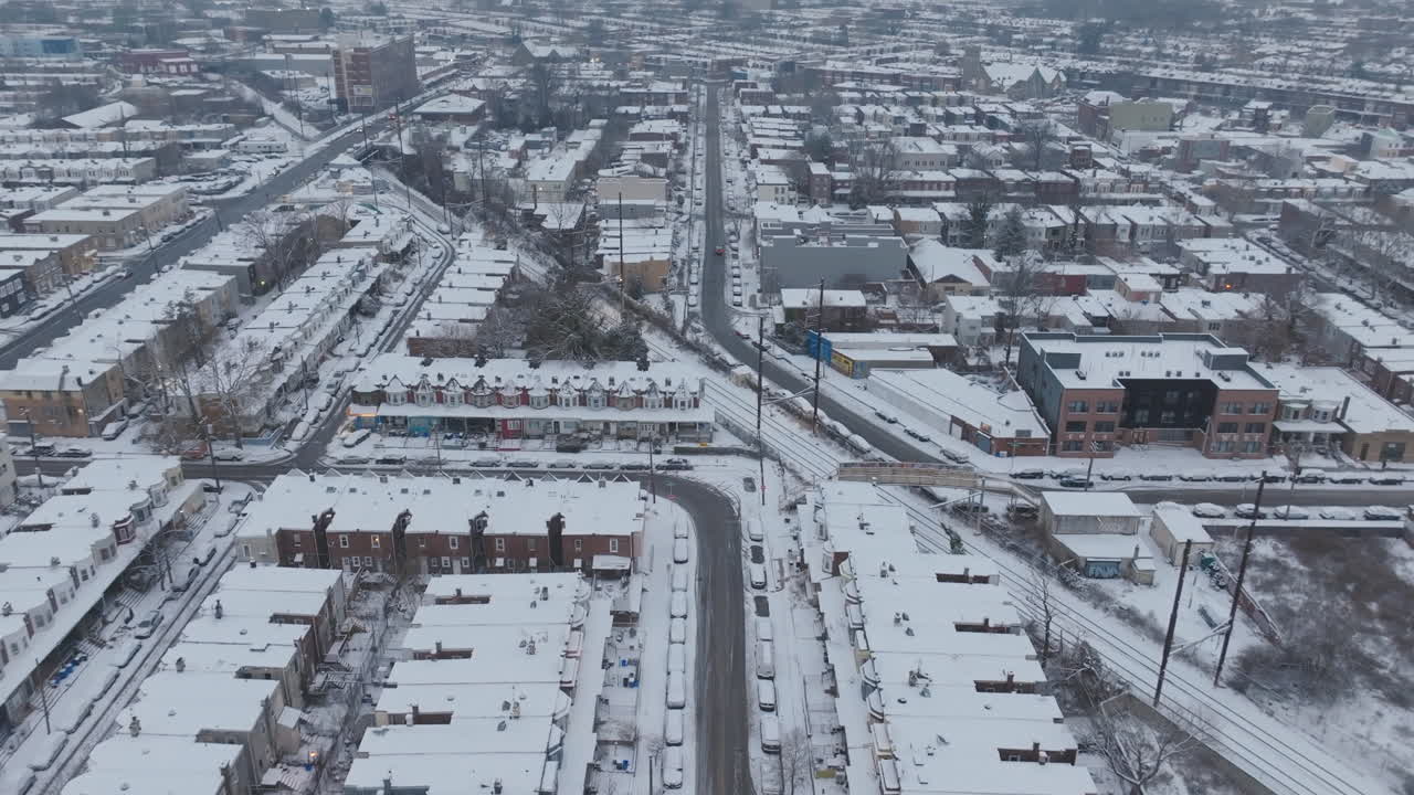 Slow aerial footage flying over snow covered neighborhoods in West Philadelphia, Pennsylvania.