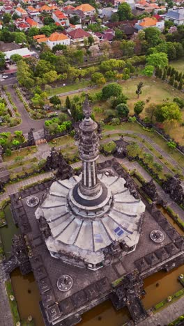 aerial vertical footage reveals the majestic bajra sandhi monument in denpasar, surrounded by landscaped gardens, walking paths, and a calm tropical atmosphere in the capital of bali