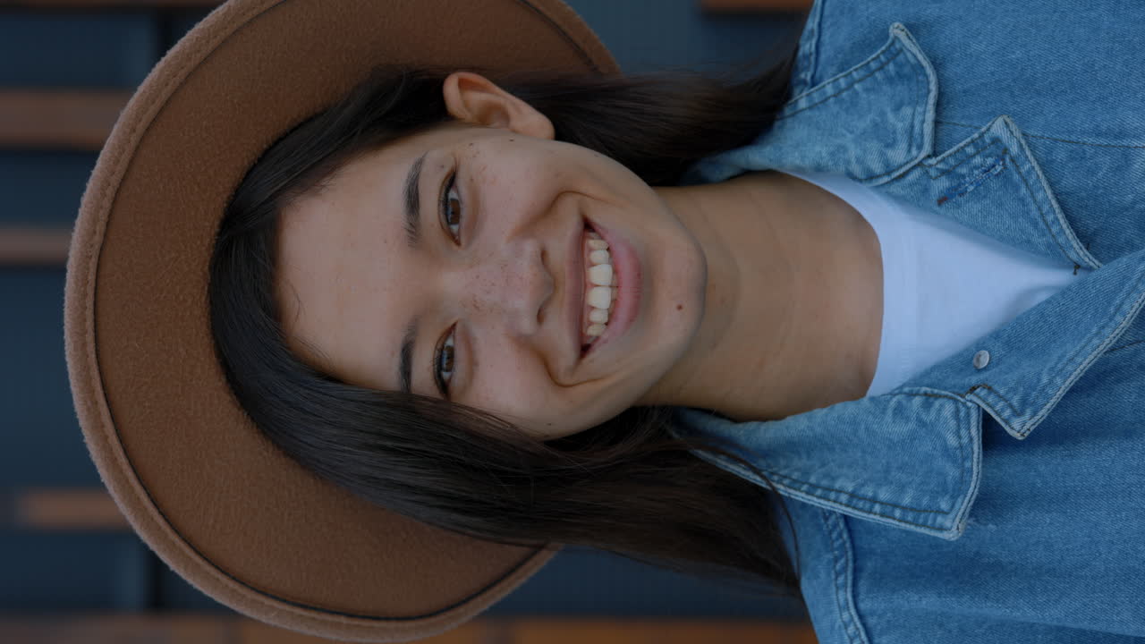 Smiling Young Woman Wearing a Hat and Denim Jacket